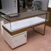 custom glass jewelry display counter with gold frame and storage cabinet