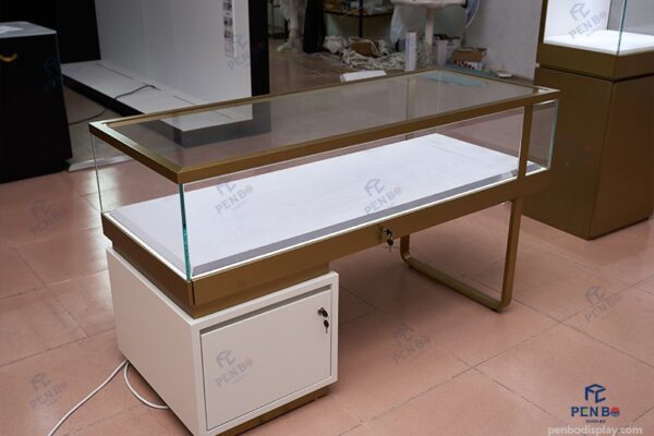 custom glass jewelry display counter with gold frame and storage cabinet