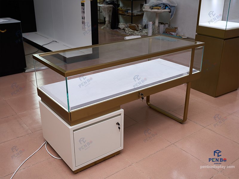custom glass jewelry display counter with gold frame and storage cabinet