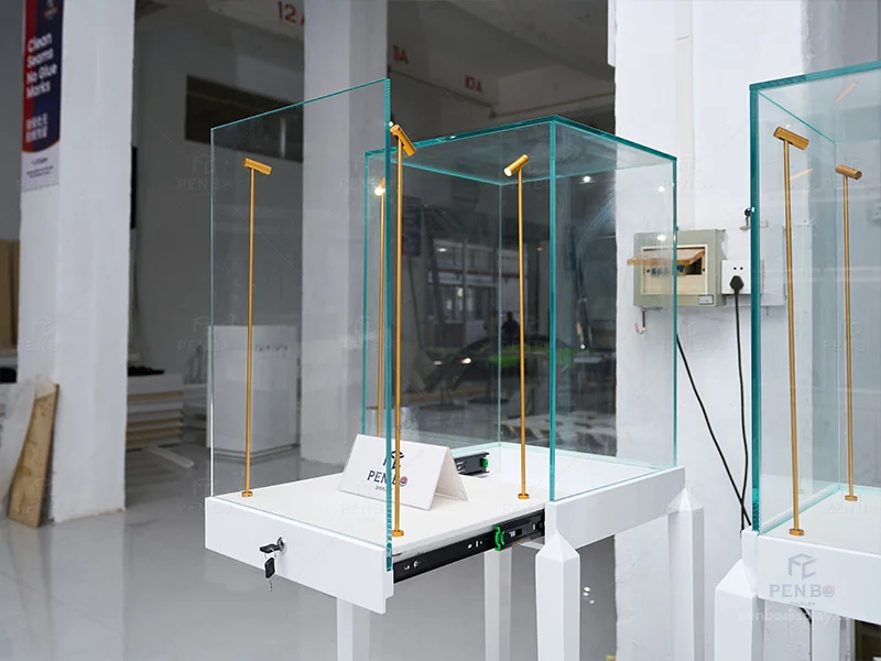 Tall white pedestal glass display cases for jewelry with built-in LED lights and locks