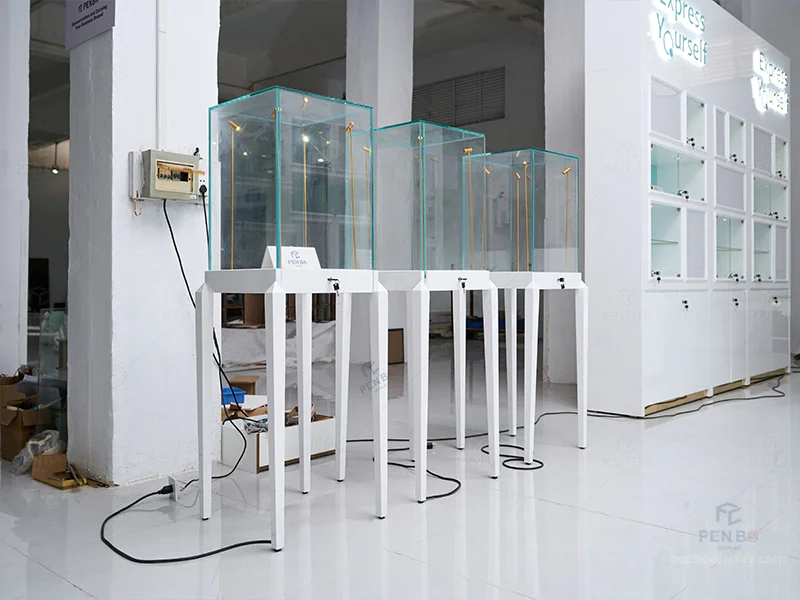 Tall white pedestal glass display cases for jewelry with built-in LED lights and locks