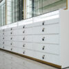 White and gold optical store glass display cabinet with built-in LED shelving and lockable storage drawers