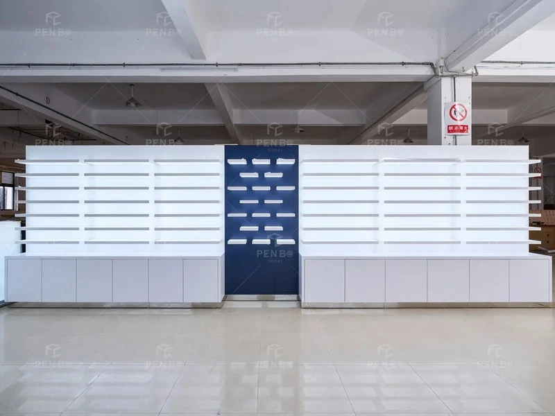 Custom optical store furniture arranged in a factory with illuminated wall shelves and white storage cabinets